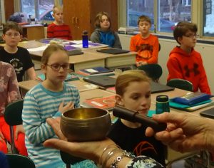 Anne Killian-Russo taps the Tibetan singing bowl