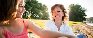 Mother and teen daughter talking outdoors